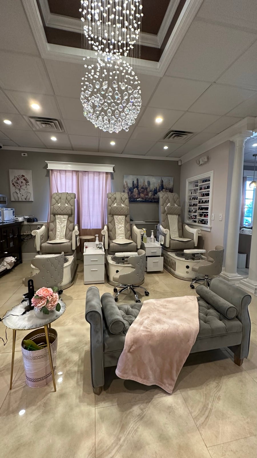 Dolce's pedicure room with crystal chandelier and white tufted thrones